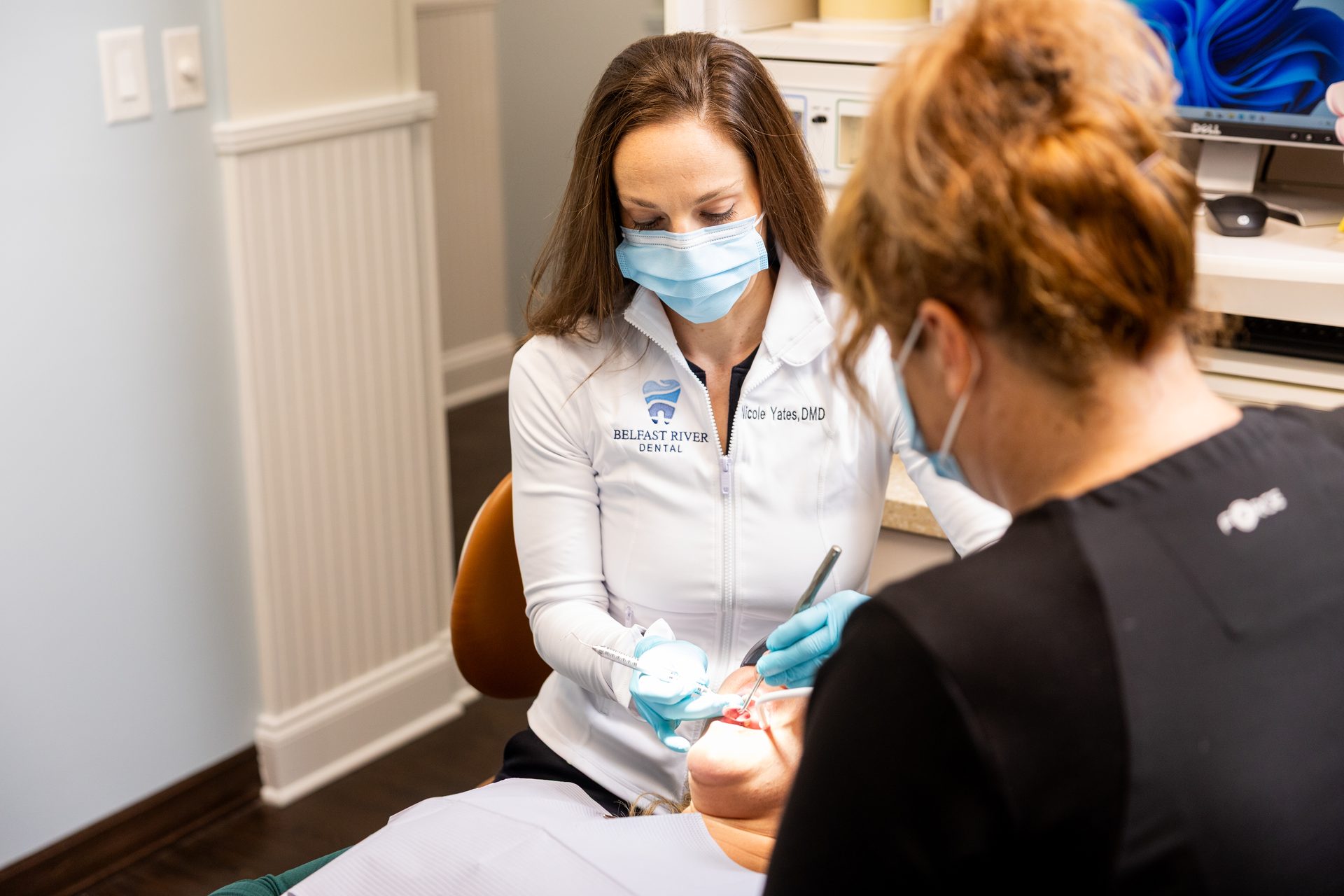 Dr. Nicole Yates examining a patient chairside at Belfast River Dental